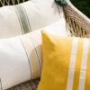 COUSSIN TEXTURÉ À RAYURES AVEC POMPONS BEIGE