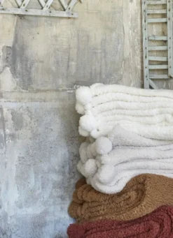 PLAID EN SHERPA AVEC FINITIONS POMPONS ÉCRU